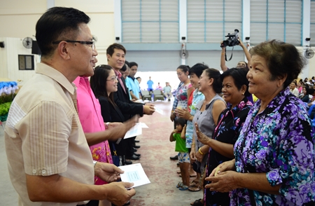 Deputy Mayor Wattana Chantanawaranon presents financial aid to Pattaya-area residents affected by flooding over the past year.